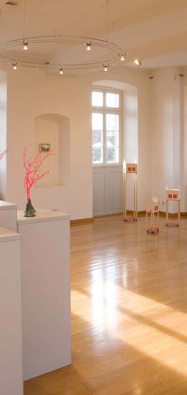 Heller Ausstellungsraum im Kommandantenhaus Neckargemünd mit Skulpturen auf weißen Podesten und zwei großformatigen Gemälden an den Wänden im Rahmen der Ausstellung "800 Jahre Dilsberg". | © Landratsamt Rhein-Neckar-Kreis | Dorothea Burkhardt