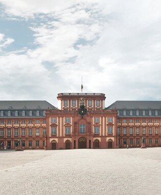 Weitläufiger Innenhof des barocken Mannheimer Schlosses mit symmetrischen Gebäudeflügeln und Bäumen entlang der Fassaden. | © Medienarchiv Rhein-Neckar-Kreis